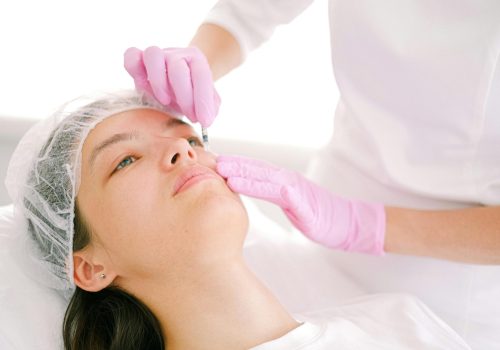 Woman receives cosmetic injection in clinical setting, enhancing beauty using modern techniques.